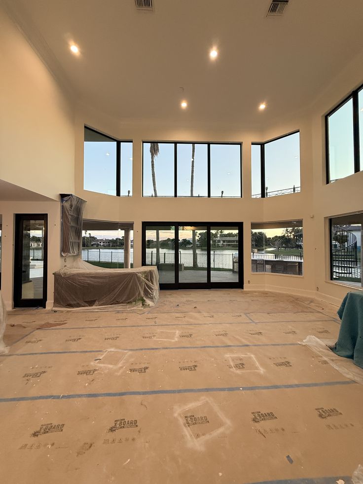 Open great room of a whole-home renovation in Coral Gables with white oak floors and arched doorways
